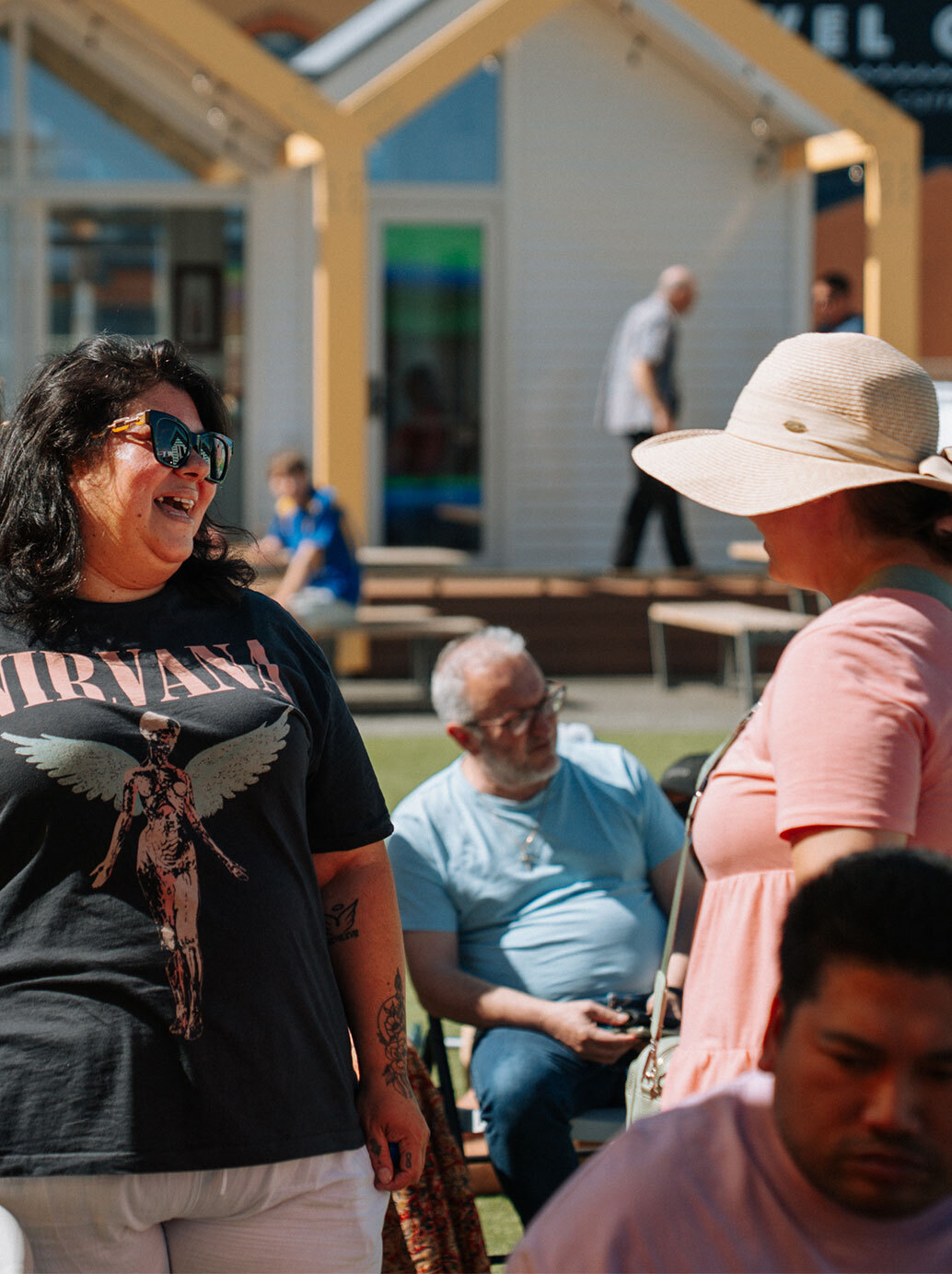 Tenancy Manager Lizel Jeptha speaks to and laughs with a resident at a community BBQ.